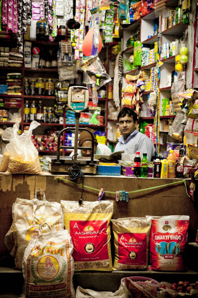 Late evening in New Delhi, India - in febraury month 2015. 2 men taking care of small grocery shop late in the night.