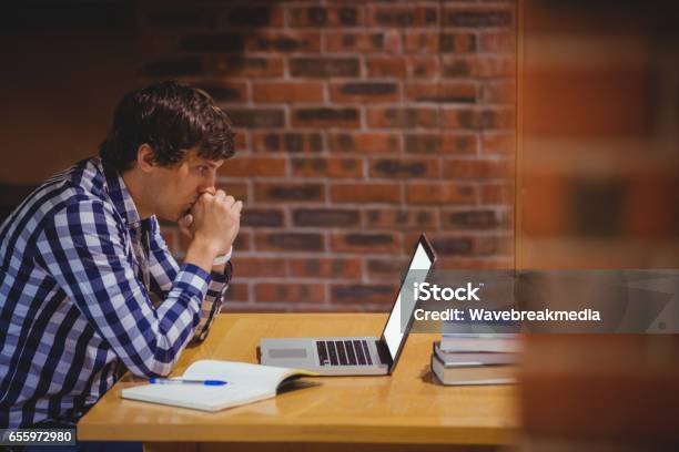 Thoughtful Student Using Laptop In Library Stock Photo - Download Image Now - 30-34 Years, 30-39 Years, Adult