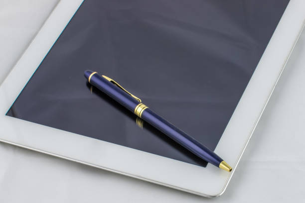 istock Tablet computer and pen from above is reflected in the glass on white background 655973408
