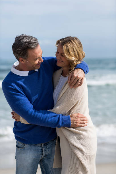 istock Mature couple embracing each other on the beach 655976074