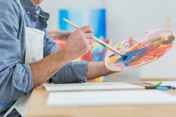 Artist blends paint on an artist's palette