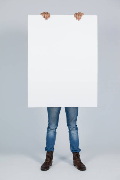istock Man holding a blank placard in front of his face 655978900