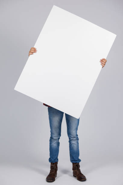 istock Man holding a blank placard in front of his face 655979670