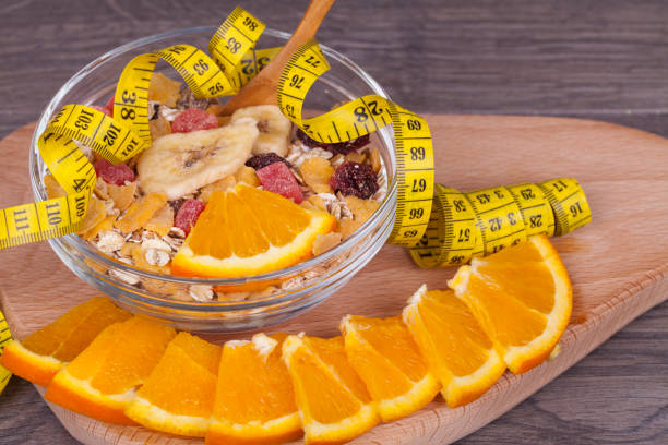 Diet concept with muesli and fresh orange on  a wooden background