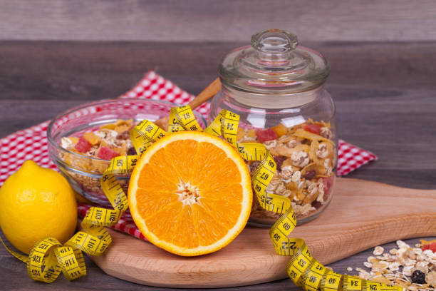 Diet concept with muesli, orange and lemonon a wooden background. With empty space for your text.