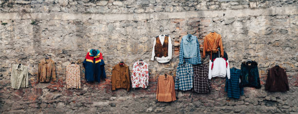 Old retro colorful clothes hanging against stone wall for sale XXXL