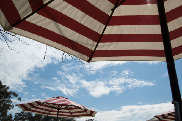 istock red and white strip umbrella with blue sky 655995520