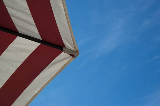 istock red and white strip umbrella with blue sky 655995574