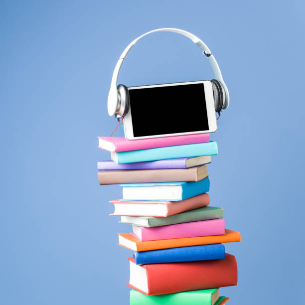 digital tablet and headphone on stack of multicolored books - hardcover book audio imagens e fotografias de stock