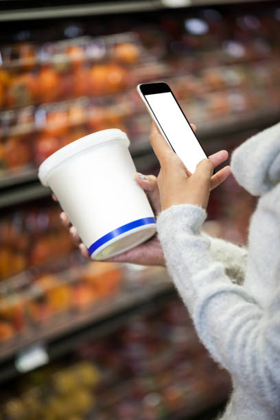 istock Woman using mobile phone while shopping for grocery 656005300