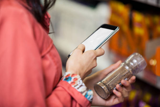 istock Woman using mobile phone while shopping for grocery 656005426