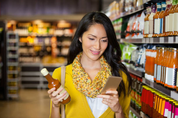 istock Woman using mobile phone while shopping for grocery 656017008