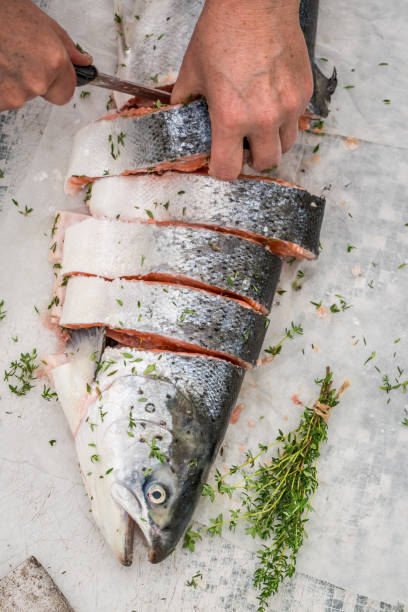 istock Slicing fresh salmon with thyme and salt 656025716