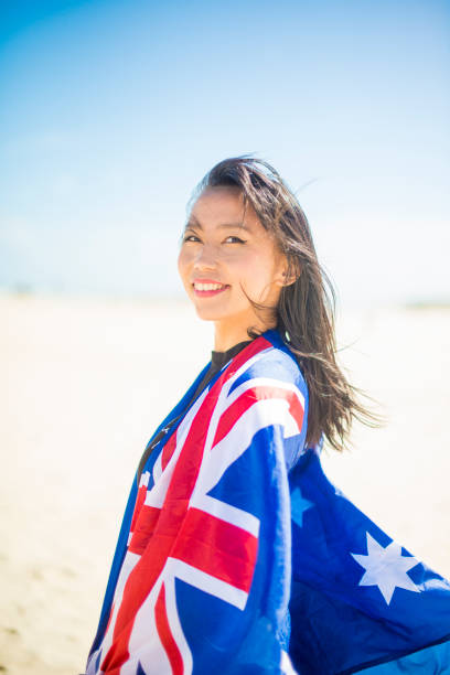 mixed race beautiful woman celebration citizenship on australian beach - australia australia day celebration flag imagens e fotografias de stock