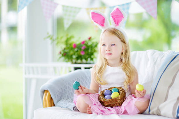 istock Cute little girl wearing bunny ears playing egg hunt on Easter 656025930