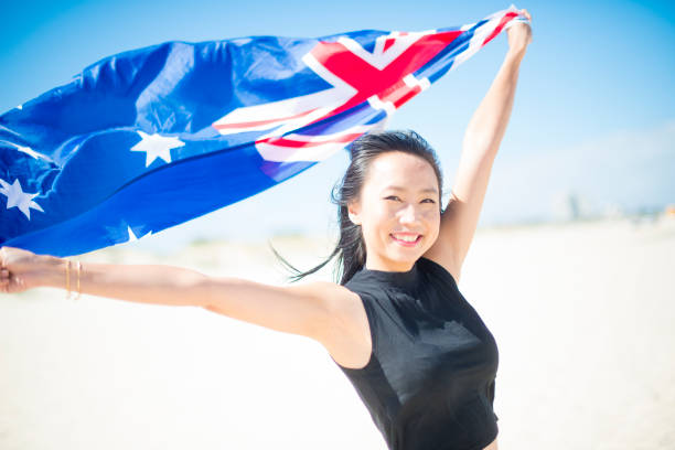 Mixed race beautiful woman celebration citizenship on Australian beach stock photo