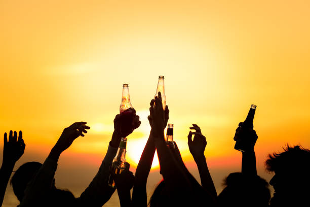 freunde eine strandparty getränke toast feier-konzept - festival alcohol stock-fotos und bilder