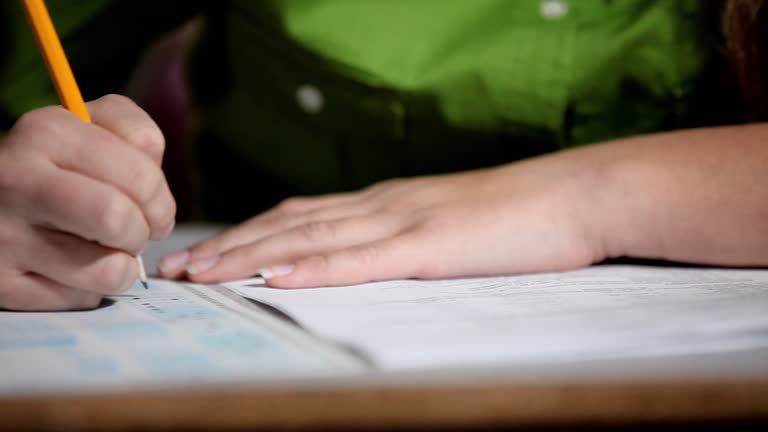 A female high school student fills in test answer using a scantron.