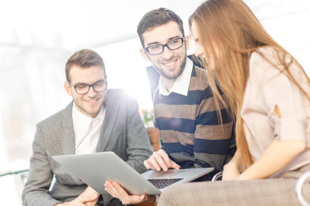 istock friendly business team working on laptop and discussing business matters 656035314