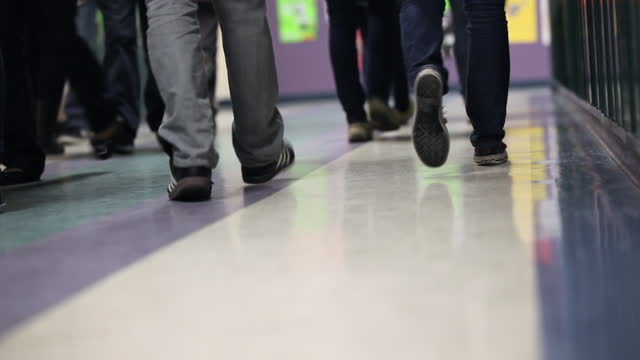 Feet of students passing each other in hall