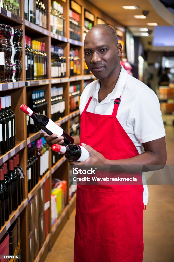 Portret van mannelijke personeel regelen van wijnflessen op plank - Royalty-free 40-44 jaar Stockfoto
