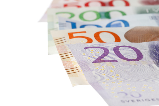 Close-up with selected focus of Swedish banknotes on white background.