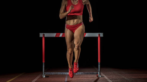 istock Female athlete running past a hurdle 656078190