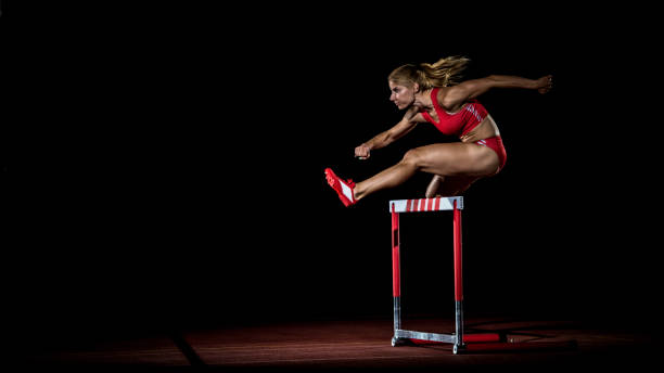 спортсменка, перепрыгивая через препятствие - hurdle hurdling track event women стоковые фото и изображения