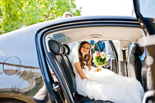 istock Cute little bride sitting at car and looking at camera at sunny day 656087414