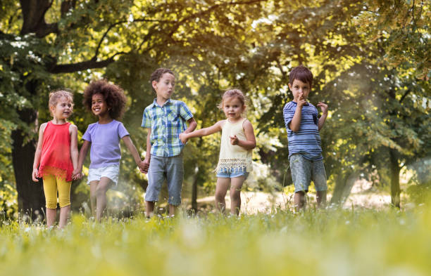 istock Happy kids holding hands and walking in the park. 656090328