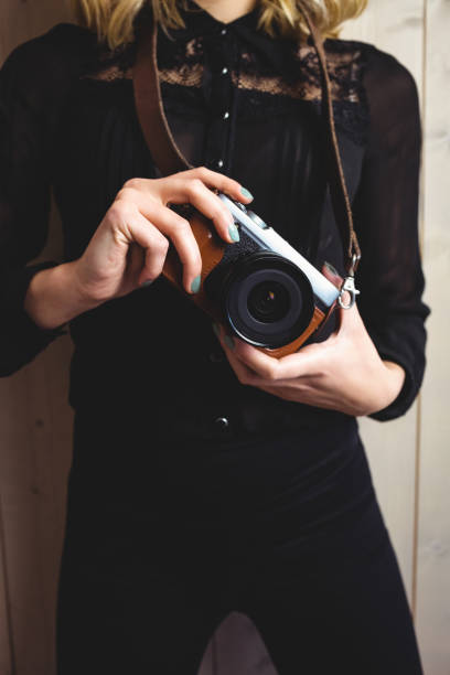 istock Mid-section of woman standing with camera 656092850