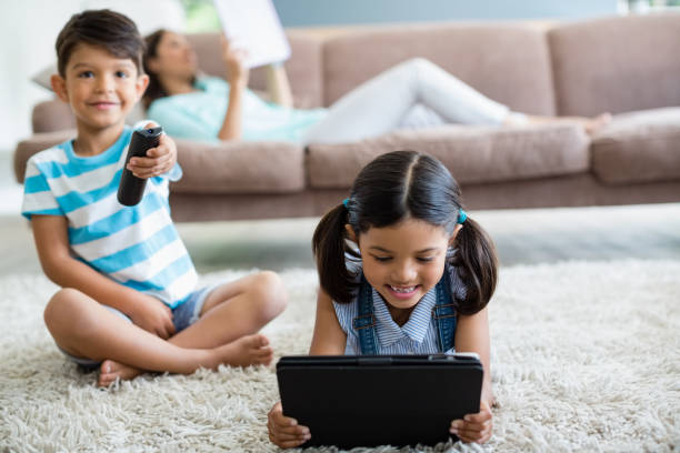 junge fernsehen und mädchen mit digital-tablette im wohnzimmer - living room people joy happiness stock-fotos und bilder