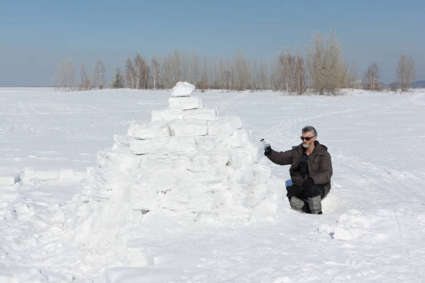 istock Man building an igloo on a glade in the winter 656104918