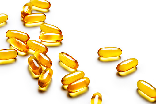 Many capsules Omega 3 scattered on white background. Top view, high resolution product. Health care concept.