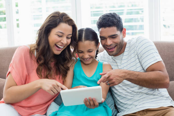 istock Parents and daughter using digital tablet in living room 656111918