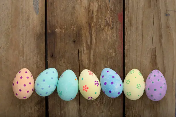 Banner image of hand-painted easter eggs over a wooden background