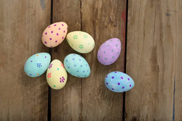 Colorful hand-painted easter eggs over a wooden background