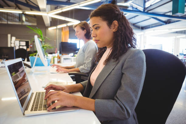 istock Woman sitting at desk and working on laptop 656122382