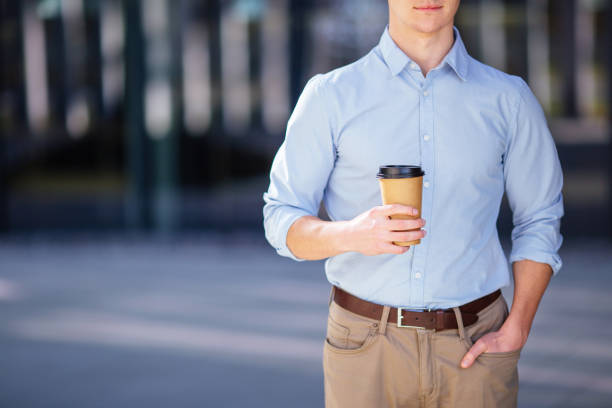 istock Businessman holding his coffee or tea drink on blur background 656123420