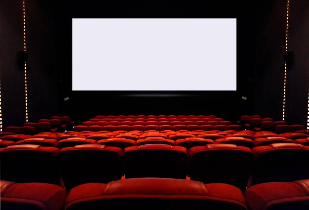 Empty cinema seats with blank white screen stock photo