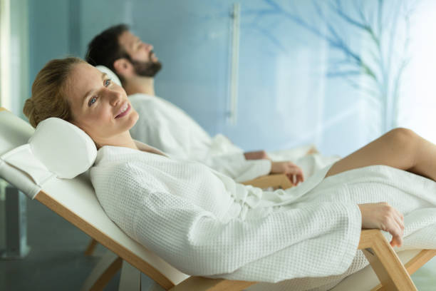 szczęśliwe małżeństwo relaksujące się w wellness spa resort - bathrobe health spa spa treatment couple zdjęcia i obrazy z banku zdjęć