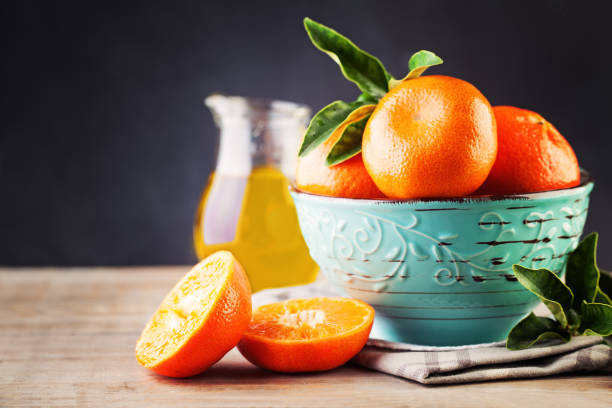 istock Ripe Mandarin Fruit  and Green Leaves on Old Rustic Wooden Board Background 656136072