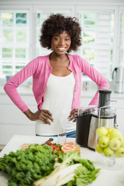 istock Smiling woman standing with hand on hip in kitchen 656136142