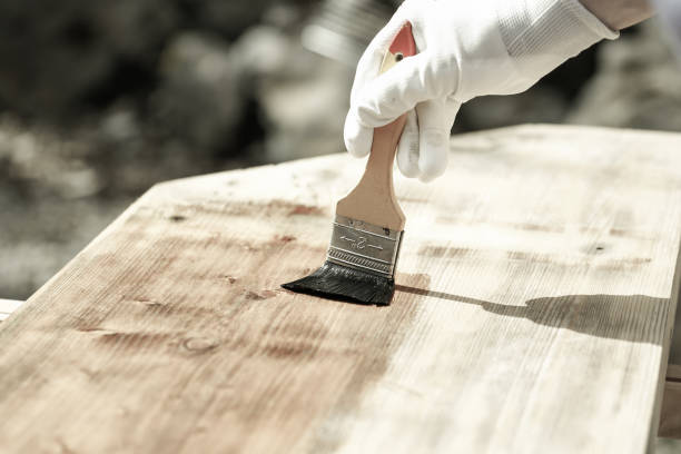 istock Painter painting wooden surface, protecting wood 656141590