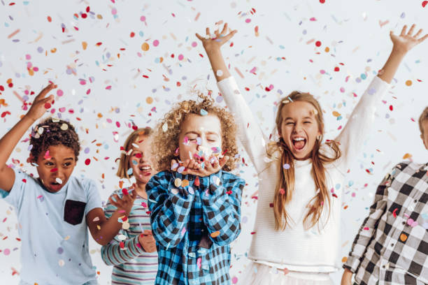 kinder in einem raum voller konfetti - spielzimmer fotos stock-fotos und bilder