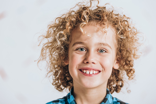 Portrait of happy blond boy with curly hair