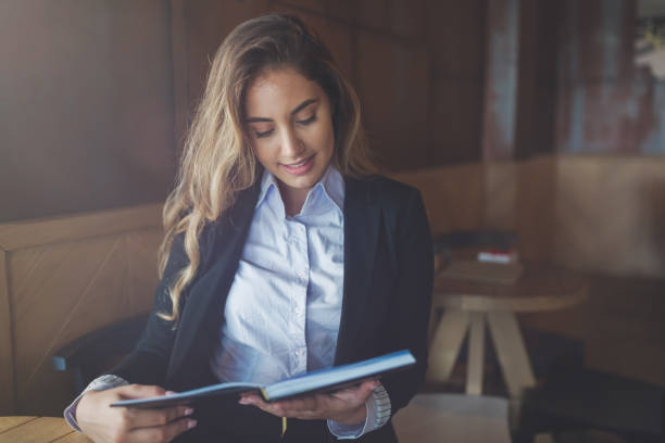 istock Beautiful woman reading notebook in cafe 656145954
