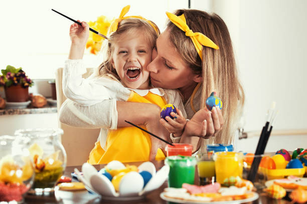 Coloring Easter eggs Mother and daughter is enjoying coloring Easter eggs. easter egg coloring stock pictures, royalty-free photos & images