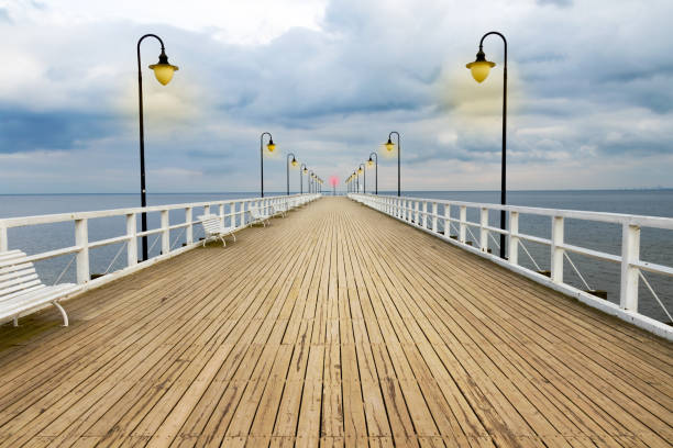 istock Symmetrical wooden pier with lanterns with dramatic sky. 656158350