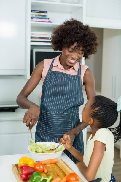istock Mother and daughter preparing salad in kitchen at home 656159514